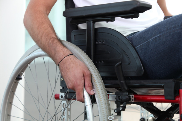 Closeup of a man's hand on the wheel of his wheelchair - Zdjęcie, obraz