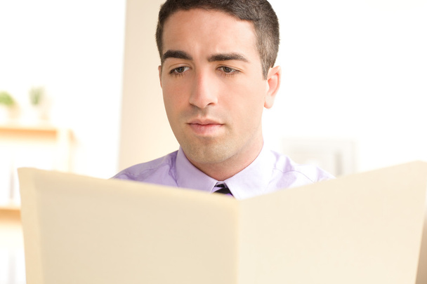 Hombre serio mirando carpeta beige
 - Foto, imagen