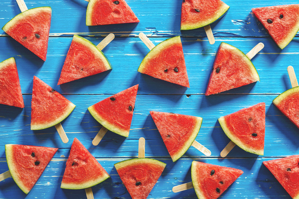 Watermeloen segment ijslollys op een blauwe achtergrond rustieke houten, Pop - Foto, afbeelding