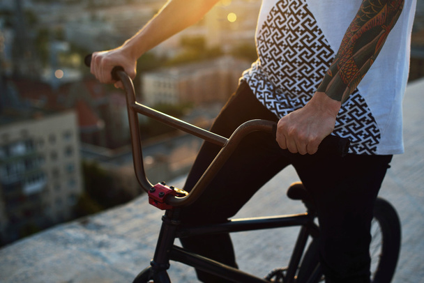 люди, подорожі, туризм, дозвілля та спосіб життя крупним планом молоді руки хіпстера тримають колесо з фіксованим велосипедом на міській вулиці
 - Фото, зображення