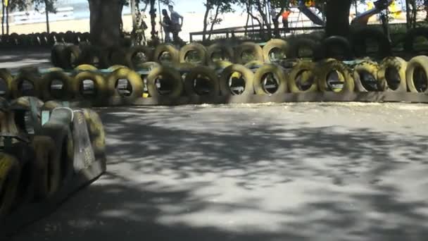 ein junger Mann in weißem Hemd, der auf der Rennstrecke ein Speedkart fährt - Filmmaterial, Video