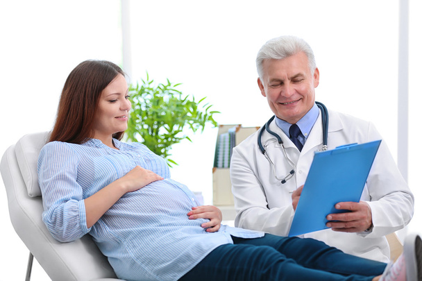 Young pregnant woman visiting doctor - Fotoğraf, Görsel
