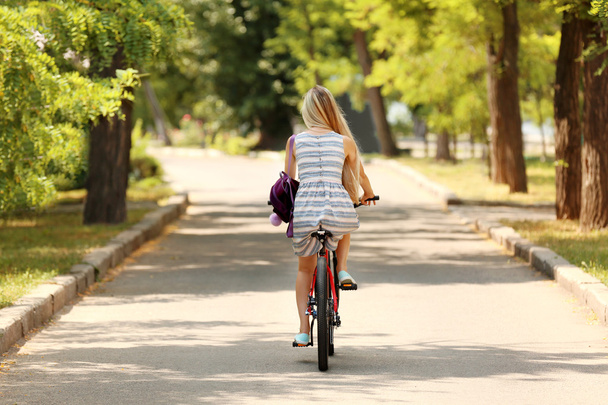 Girl riding bicycle on street - Zdjęcie, obraz