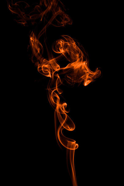 Abstract orange smoke-like shape against black background - Foto, Imagen