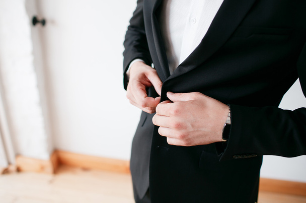 Making business look good. Close-up of man buttoning his jacket while standing against white background - Photo, Image