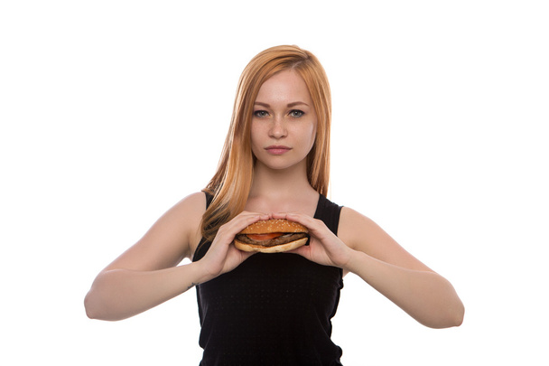 young beautiful girl with red hair holding a Burger in her hands isolated on white background - Фото, изображение