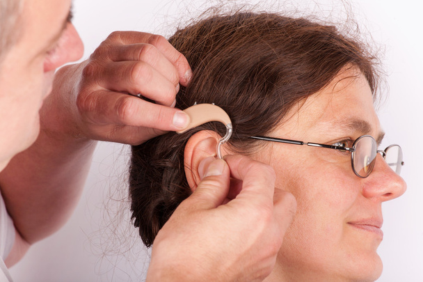 Doctor inserting a hearing aid - Фото, зображення