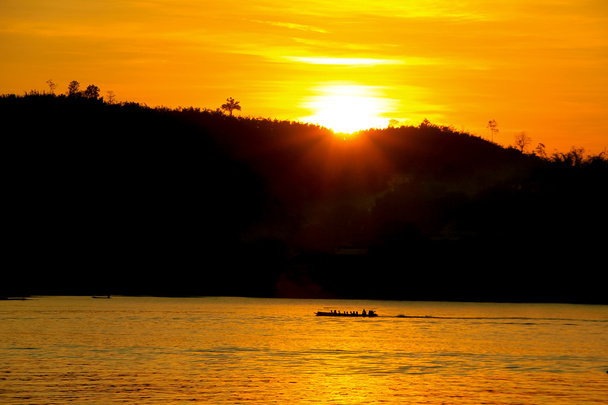 sunset behind the mountain with boat running along the river san - Fotografie, Obrázek