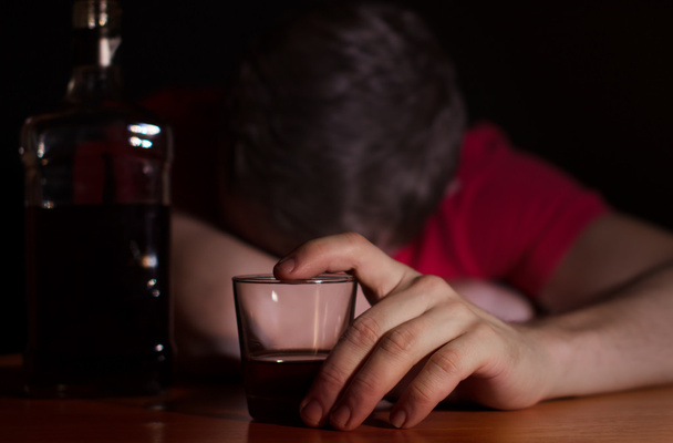 Drunk man asleep at a table - 写真・画像