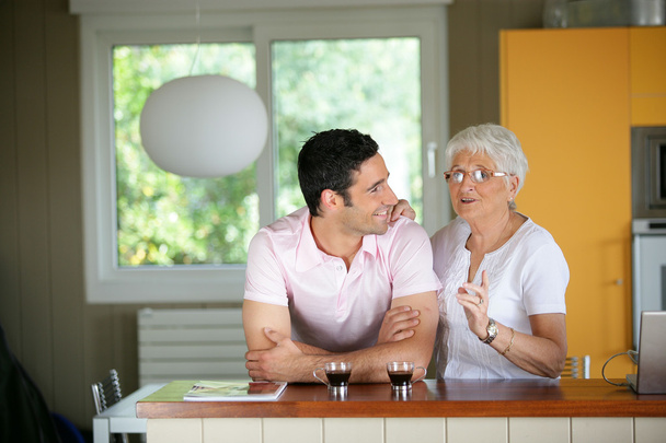 Adult man with his mother in a kitchen - Foto, Imagen