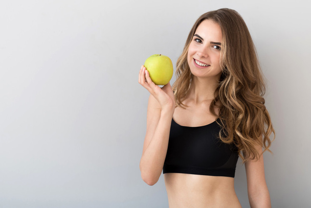 Positive beautiful woman holding an apple - Fotografie, Obrázek