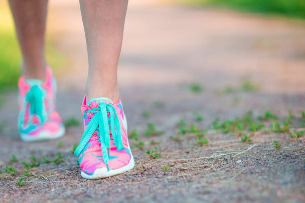 Δραστήριου τρόπου ζωής γυναίκα αθλητής δένοντας παπούτσια για τρέξιμο. Σπορ κορίτσι ετοιμάζεται για τζόκινγκ προπόνηση. Κοντινό πλάνο του παπούτσια για τρέξιμο. - Φωτογραφία, εικόνα