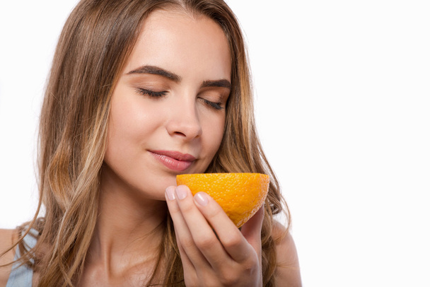Delighted woman holding orange - Foto, afbeelding