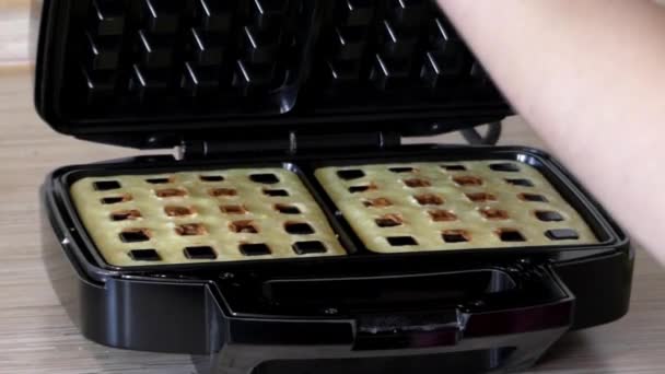 Ragazza che prepara waffle belgi in un ferro speciale per waffle
. - Filmati, video
