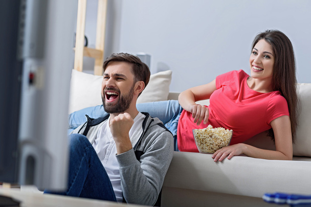 Man and woman watching tv on couch - Valokuva, kuva