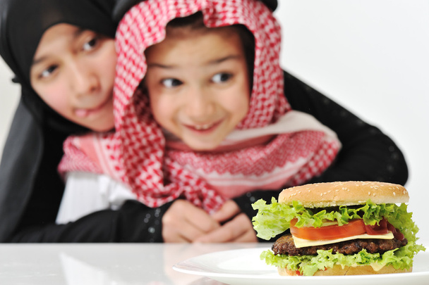 Árabe chica y chico con grande hamburguesa
 - Foto, imagen