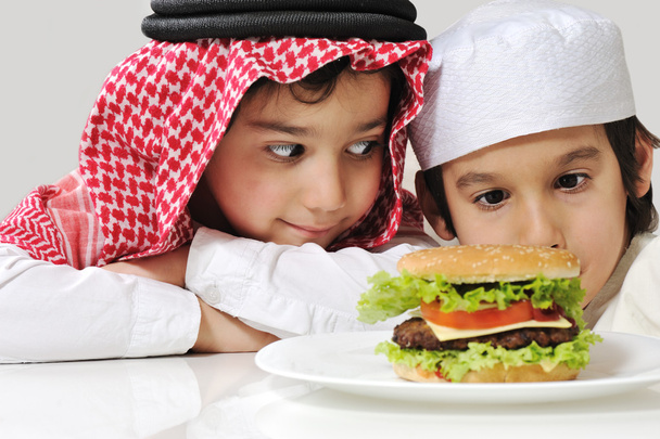 Арабские двое маленьких детей с большим бургером
 - Фото, изображение