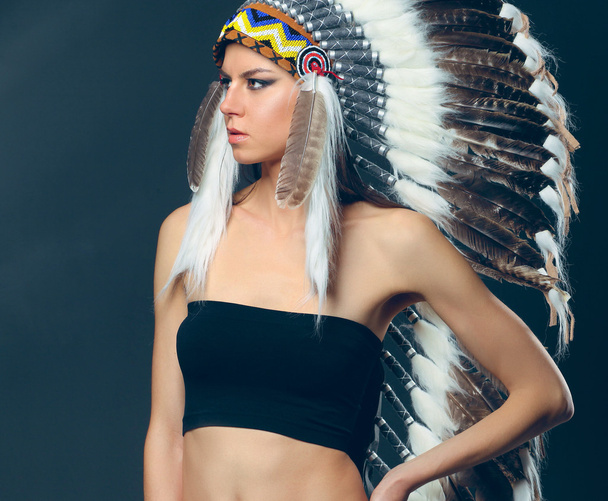Beautiful woman in native american costume with feathers - Фото, изображение