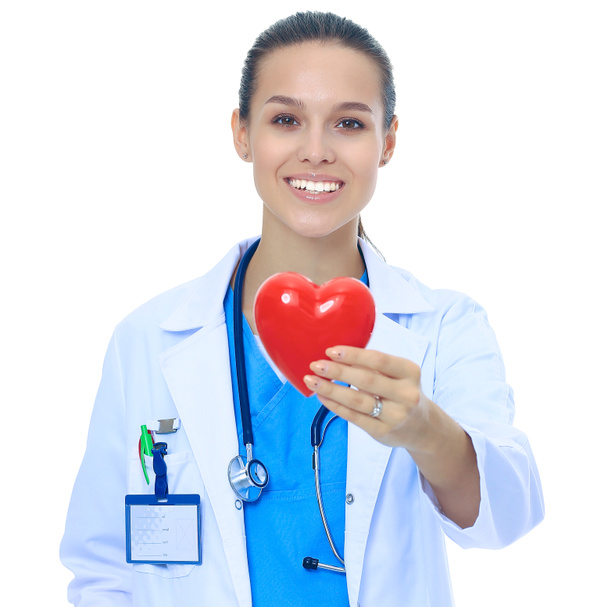 Positive female doctor standing with stethoscope and red heart symbol isolated - 写真・画像