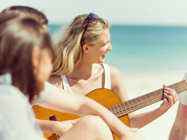 Beautiful young woman playing guitar on beach - Φωτογραφία, εικόνα