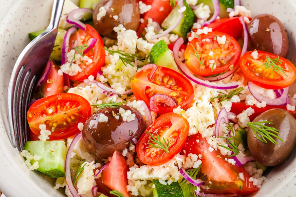 salade met tomaten, komkommer, olijven, uien, feta en couscous - Foto, afbeelding