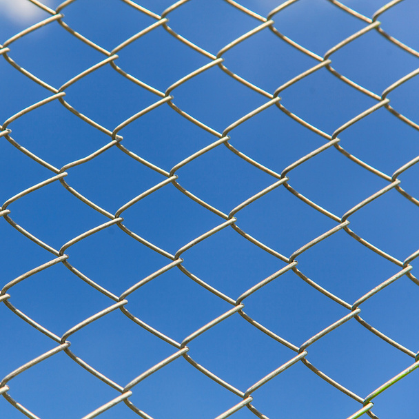 Дротовий паркан на фоні блакитного неба
 - Фото, зображення