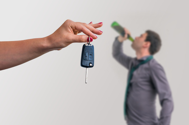 Femme montrant des clés de voiture et son mari buvant de l'alcool
 - Photo, image