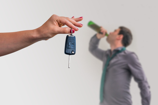 Femme montrant des clés de voiture et son mari buvant de l'alcool
 - Photo, image