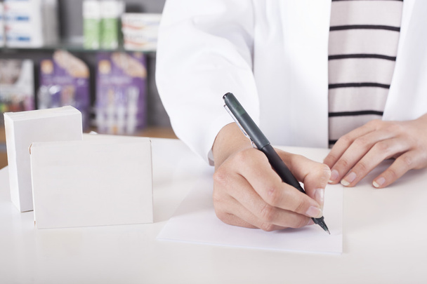 Pharmacist or doctor writing with tablet package with copy space - Fotografie, Obrázek