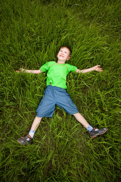 Kleiner Junge liegt auf dem Gras - Foto, Bild