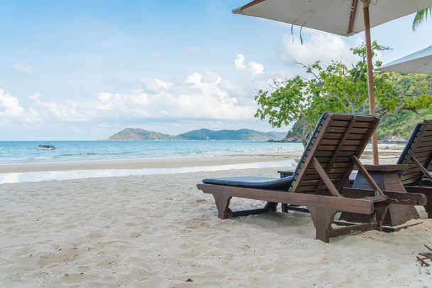 Bellissime sedie a sdraio con ombrellone su spiaggia tropicale di sabbia bianca
 - Foto, immagini