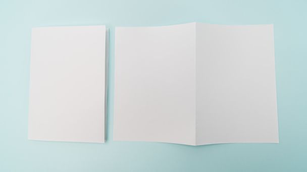 Bifold white template paper on blue background . - Фото, изображение