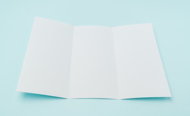 Trifold white template paper on blue background . - Foto, Bild