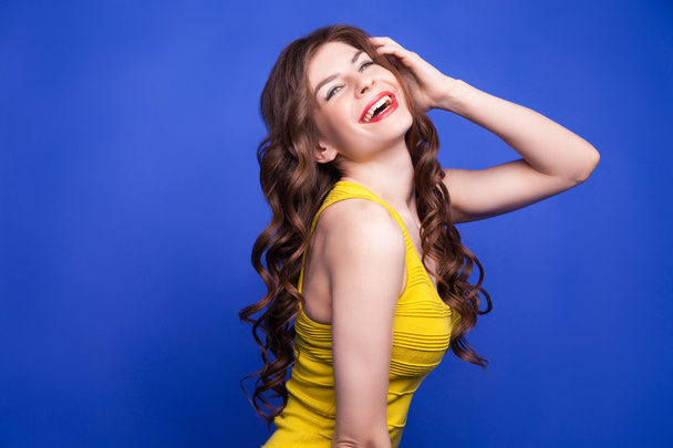 Cheerful model in yellow dress smiling - Foto, afbeelding