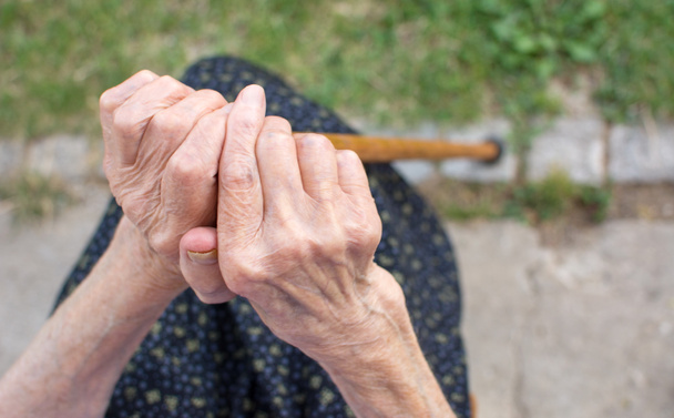 Vanha nainen kädet kädessään kävelykeppi
 - Valokuva, kuva