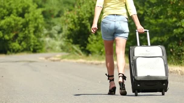  Slow motion. Hot summer and  silhouette of sexy girl with  suitcase on  road. - Footage, Video