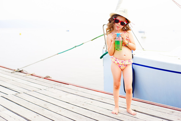 little girl drinking sparkling water on the pier - Fotografie, Obrázek