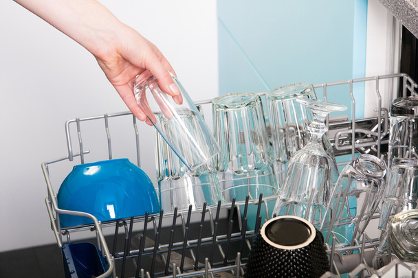 Жінка спорожнила посудомийну машину
 - Фото, зображення