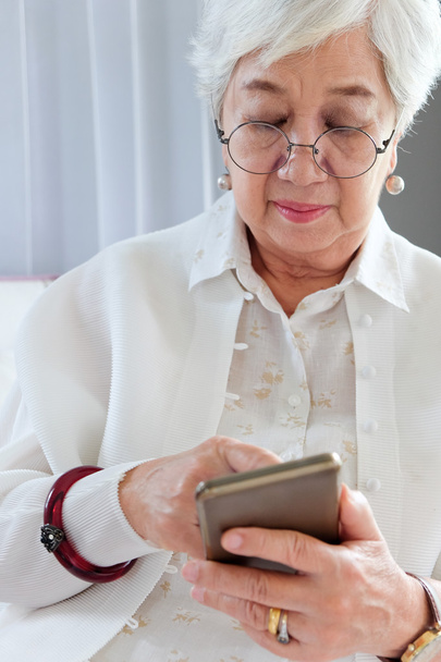 Старша жінка використовує свій мобільний телефон
. - Фото, зображення