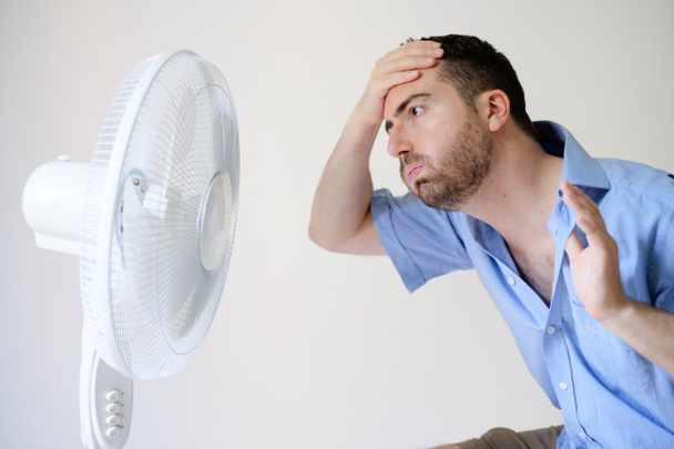 Opróżniany człowieka uczucie gorąca przed wentylatorem  - Zdjęcie, obraz