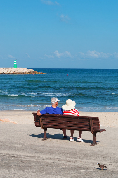 Τελ Αβίβ, Ισραήλ, Μέση Ανατολή, 31/08/2015: ένα ζευγάρι σε ένα παγκάκι στην παραλία στο Τελ Αβίβ, τρέχει κατά μήκος της ακτής της Μεσογείου και προσφέρει όμορφες και ρομαντικές θαλάσσιες τοπίων προβολή - Φωτογραφία, εικόνα