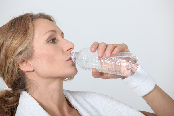 Sporty woman drinking bottle of water - Photo, image