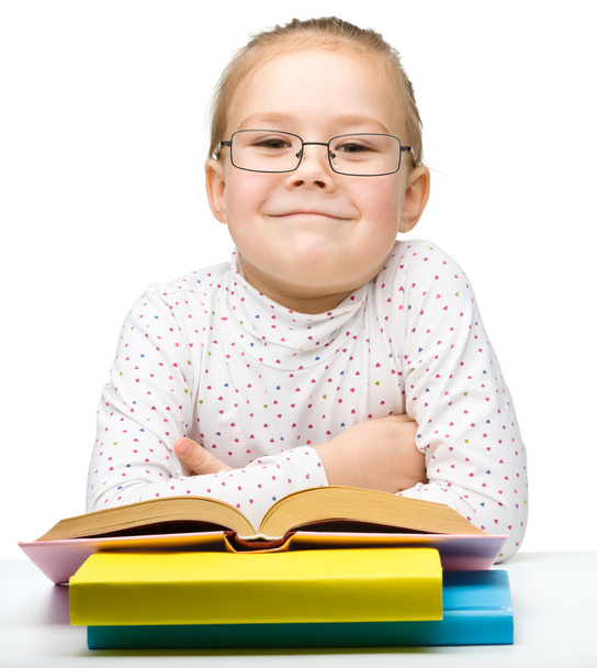 Мила весела дівчинка читає книгу
 - Фото, зображення