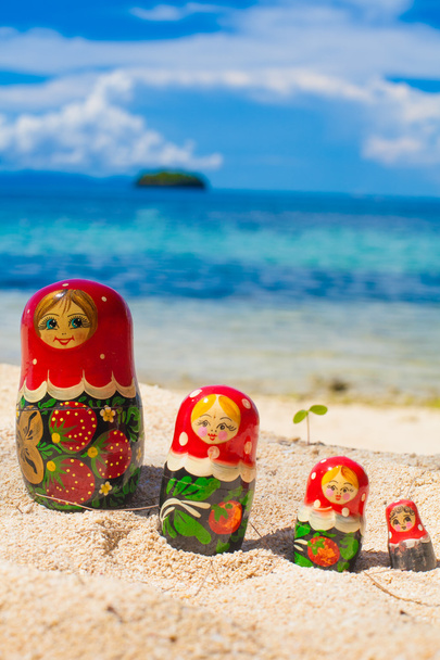 Photo Rows Puzzle Russian Dolls Matrioshka Souvenir Untouched Tropical Beach in Bali Island. Vertical Picture. Blurred Background. Closeup. - Foto, Imagen