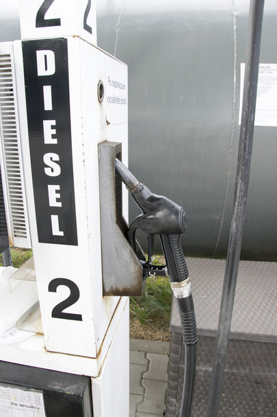 Detail of a hand holding a fuel pump at a station - Photo, Image
