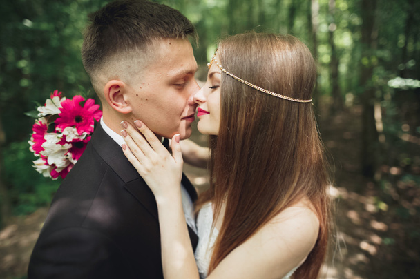 Beautiful young wedding couple is kissing and smiling in the park - Φωτογραφία, εικόνα