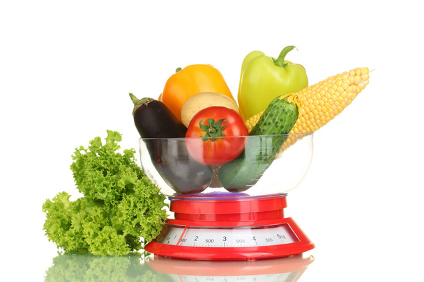Ripe fresh vegetables in the kitchen scales isolated on white - 写真・画像