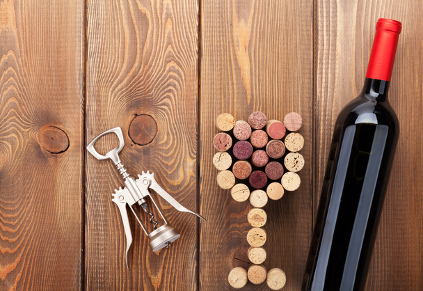 Botella de vino tinto, corchos en forma de vidrio y sacacorchos
 - Foto, Imagen