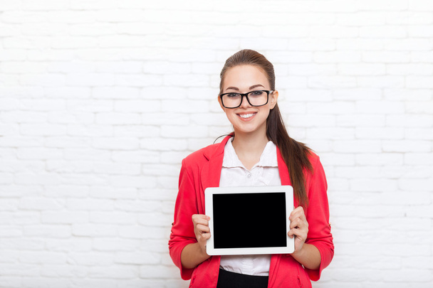 Businesswoman show tablet computer screen with empty copy space wear red jacket glasses happy smile - Fotó, kép