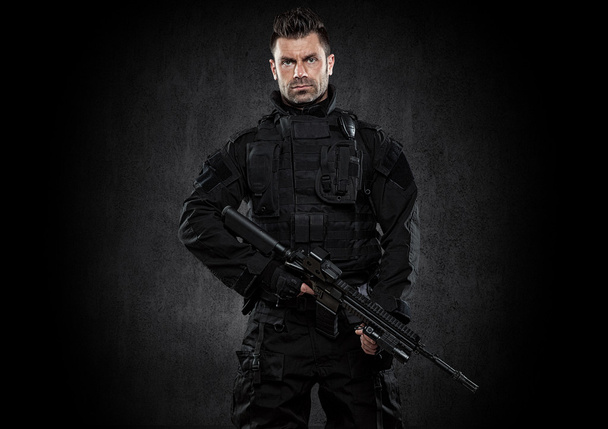 Spec ops police officer SWAT in black uniform studio - Photo, Image
